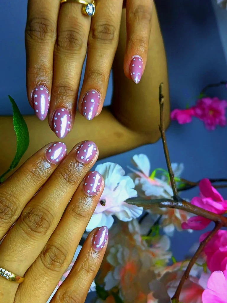 Elegant pink polka dot gel nail art by a nail salon in Jhamsikhel