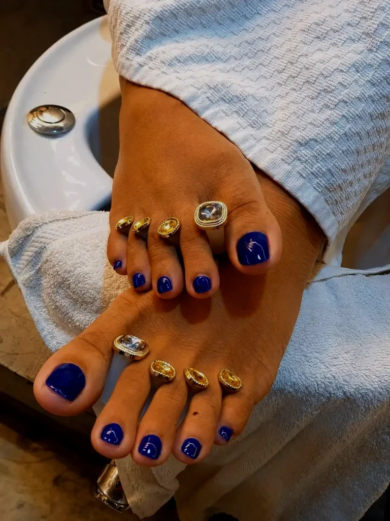 Professional pedicure with glossy royal blue toenail polish at a premium nail salon in Jhamsikhel