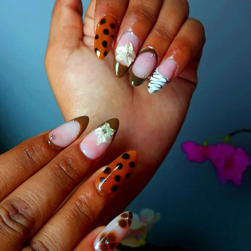 Beautiful almond-shaped nail extensions with floral and animal print designs at a nail salon in Jhamsikhel